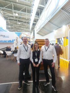 A woman and two men at a trade fair